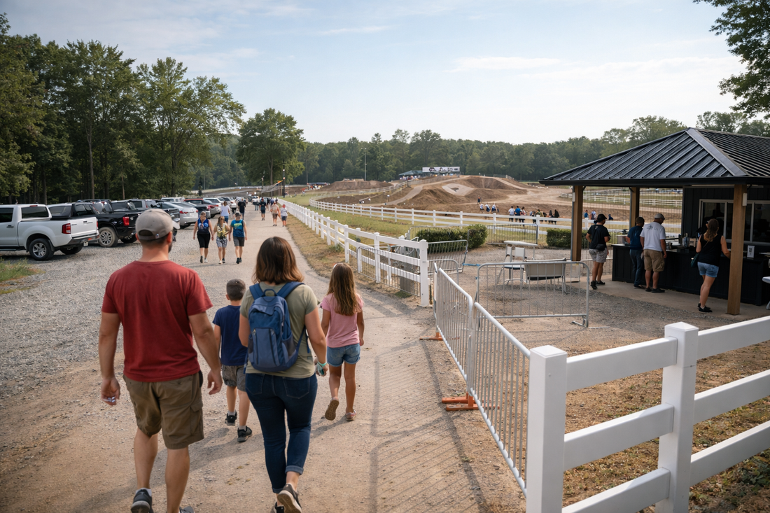 Professional motocross track facility entrance showing controlled parking flow, check-in area, and spectators walking toward the track