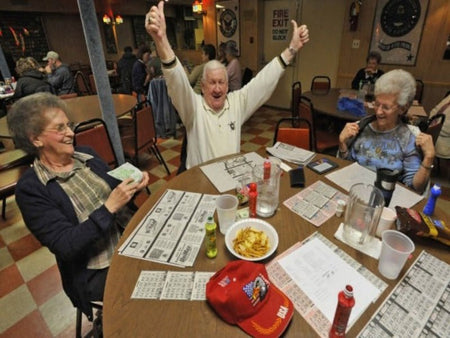 Photorealistic scene inside a U.S. bingo hall with smiling senior players celebrating a win at a table, symbolizing community, excitement, and success — used for the Bingo Hall Business Plan Template by BPlanMaker.